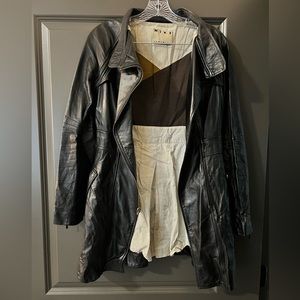 Black leather Mike Gonzalez trench coat. Zipper cuff detail with pockets.